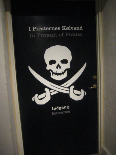 Some museums produce bilingual or multilingual exhibitions. But what do we know about international museum visitors? Photo from the entrance to the bilingual exhibition "In Pursuit of Pirates - The Danish Navy vs. Pirates in Five Centuries" or in Danish: "I piraternes kølvand – flådens kamp med pirater i 500 år" at Orlogsmuseet, Copenhagen, 2012. Photo: Jonas Abkjær Andersen