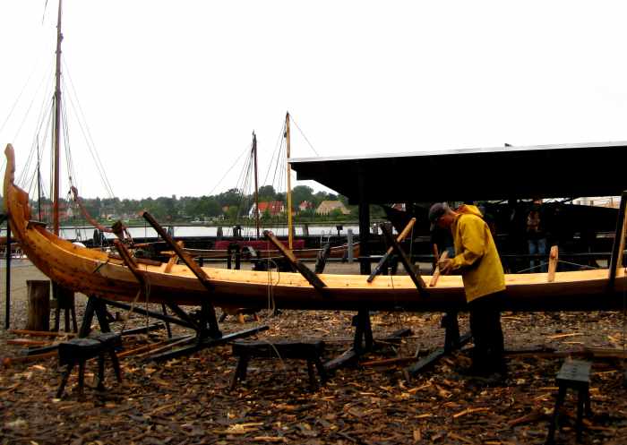 På værftet på Vikingeskibsmuseet i Roskilde laver håndværkere og skibsbyggere en ny rekonstruktion af et vikingeskib (2011). Håndværkeren bruger noget immaterielt (evner, kunnen og bevægelser) til at frembringe et materielt udtryk (et skib). Foto: Jonas Abkjær Andersen